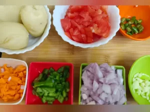 Fresh burger ingredients including Capsicum, Potato, tomato, onion, Cucumber, Garlic and raw patty for homemade burger recipe